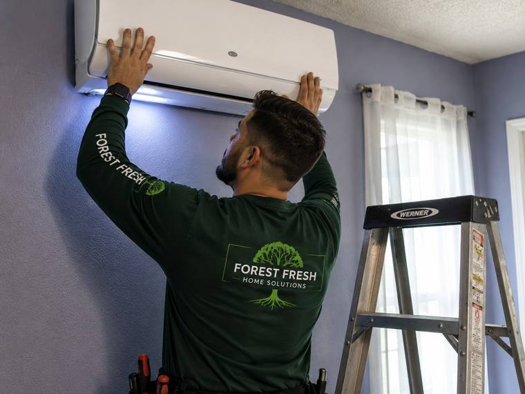 Forest Fresh technician installing mini-split heating and cooling system.